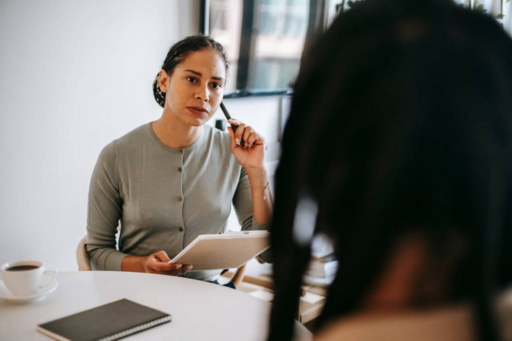 A thoughtful woman attentively listening during a conversation, emphasizing the importance of silence in communication.