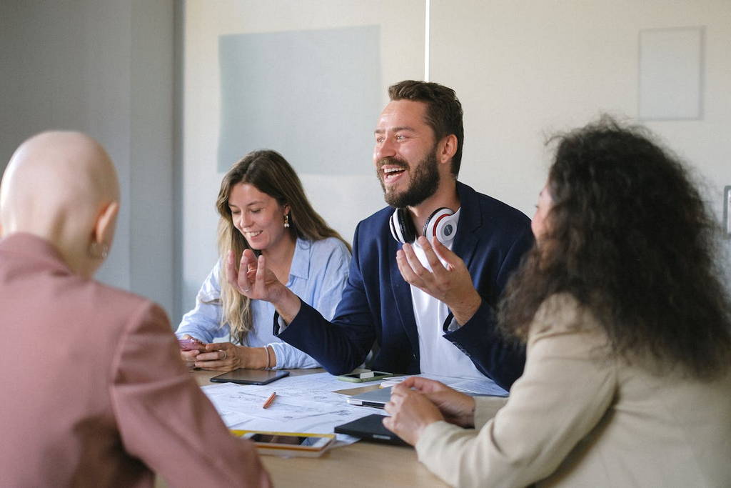 A diverse team engaging in an enthusiastic discussion, showcasing emotional intelligence and effective leadership in the workplace.